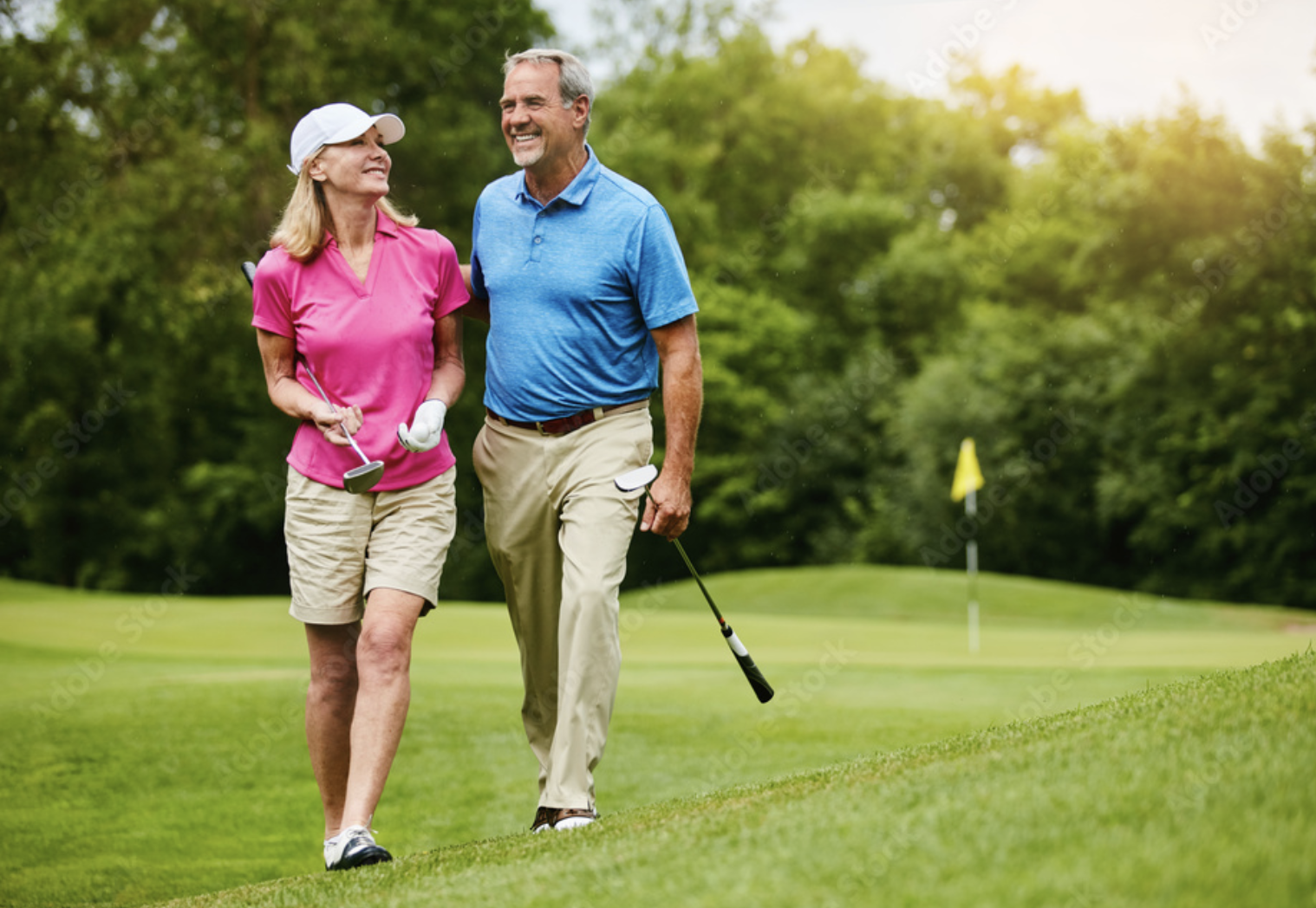 Two golfers walking the fairway together on a sunlit course